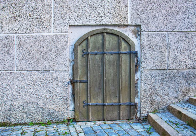 Antique wooden green door to the basement of a medieval castle